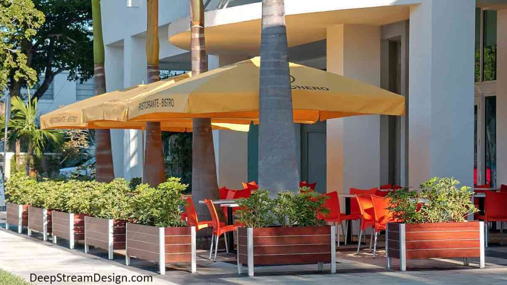 Modern narrow wood and aluminum restaurant planters create an outdoor cafe under the palms on a tropical Miami sidewalk.