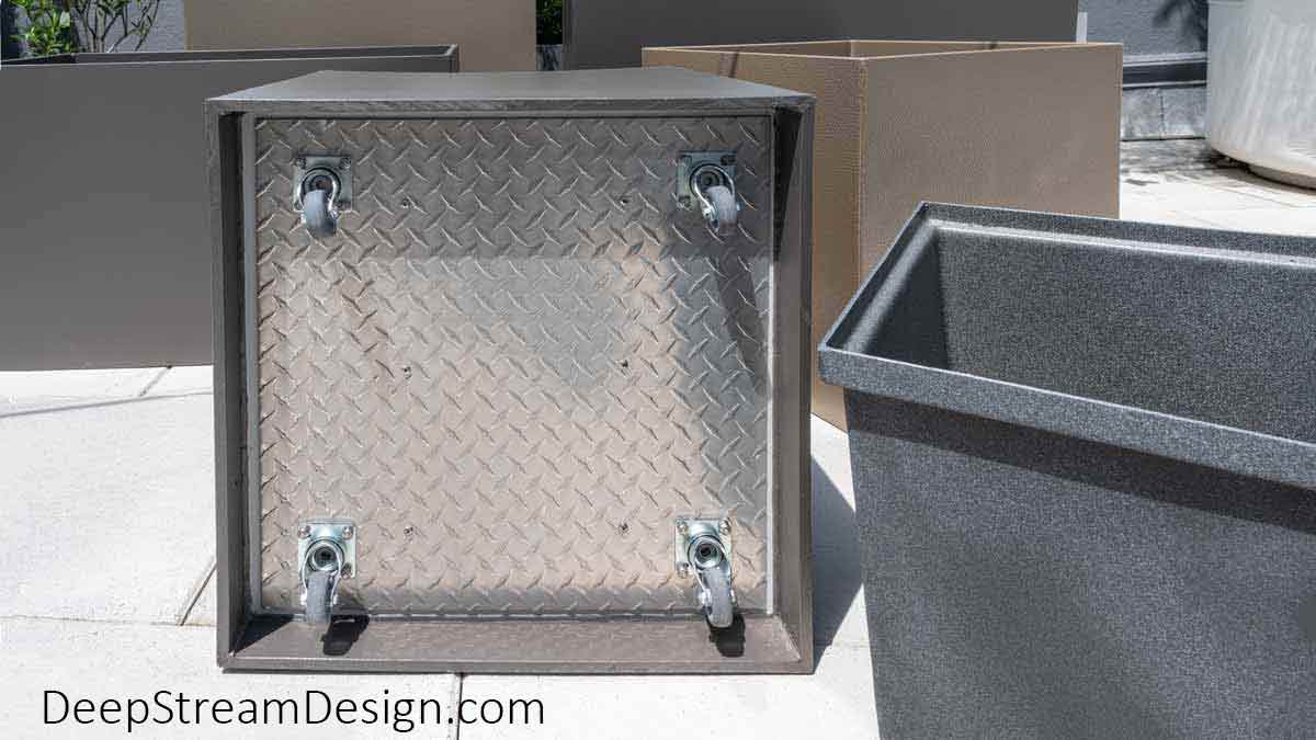 Modern tall and short, square, and rectangular Food Safe Plastic Planters on Wheels are shown in a tropical Miami roof deck setting. with one planter on its side to show the hidden caster wheels' aluminum mounting plate.
