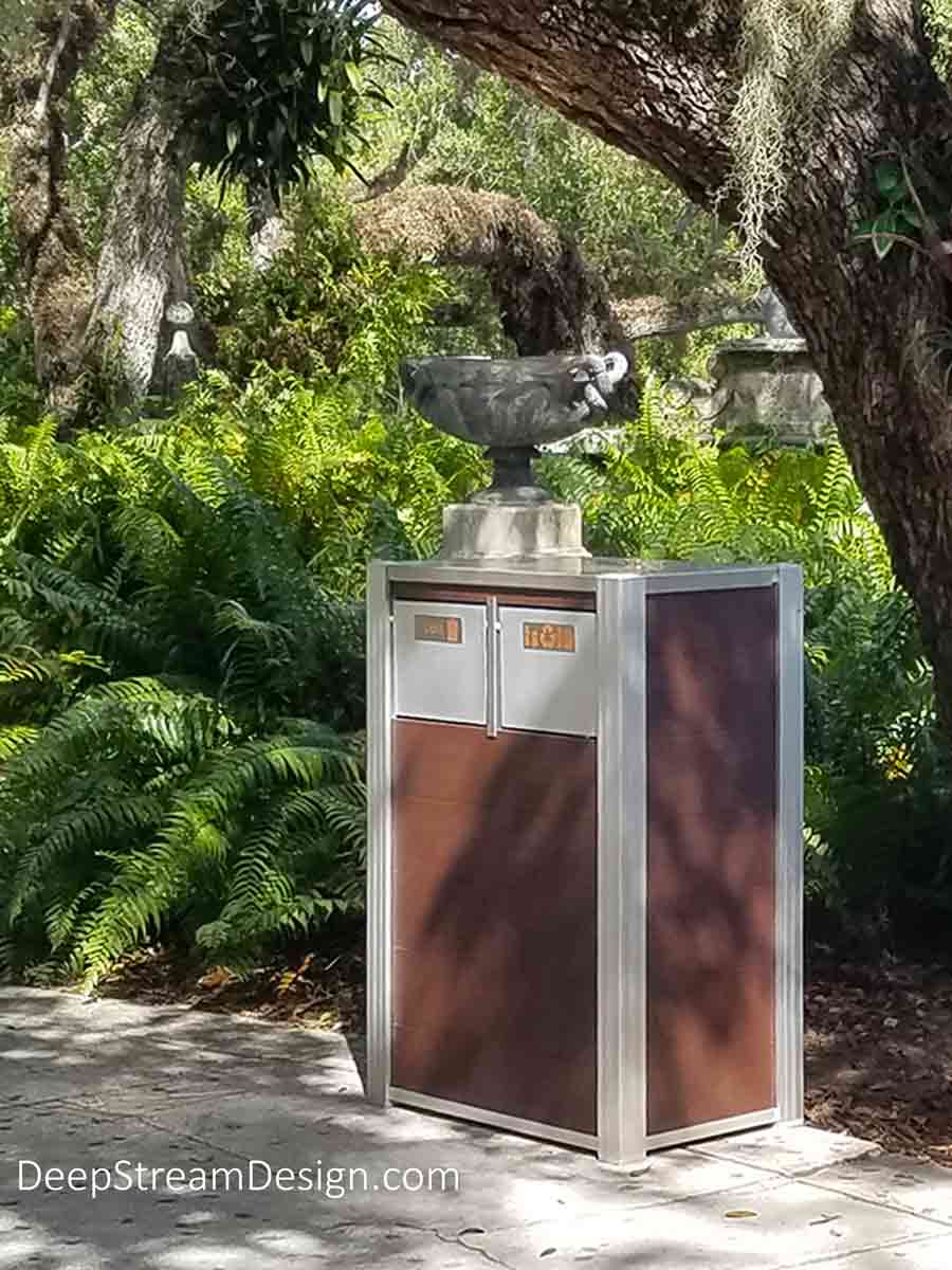 Standing guard in a tropical botanical garden, DeepStream’s modern dual stream 21-gallon Oahu Commercial Combined Recycling and Trash Receptacle crafted with Ipe Brown-colored no-maintenance recycled plastic lumber serves the endless stream of visitors to this unique county park along the shores of Biscayne Bay. Fitted with 316 stainless steel lid and hinges, marine aluminum push flaps, and leakproof 21-gallon inner bins, this fixture will serve for decades, despite torrential rains and hurricanes.