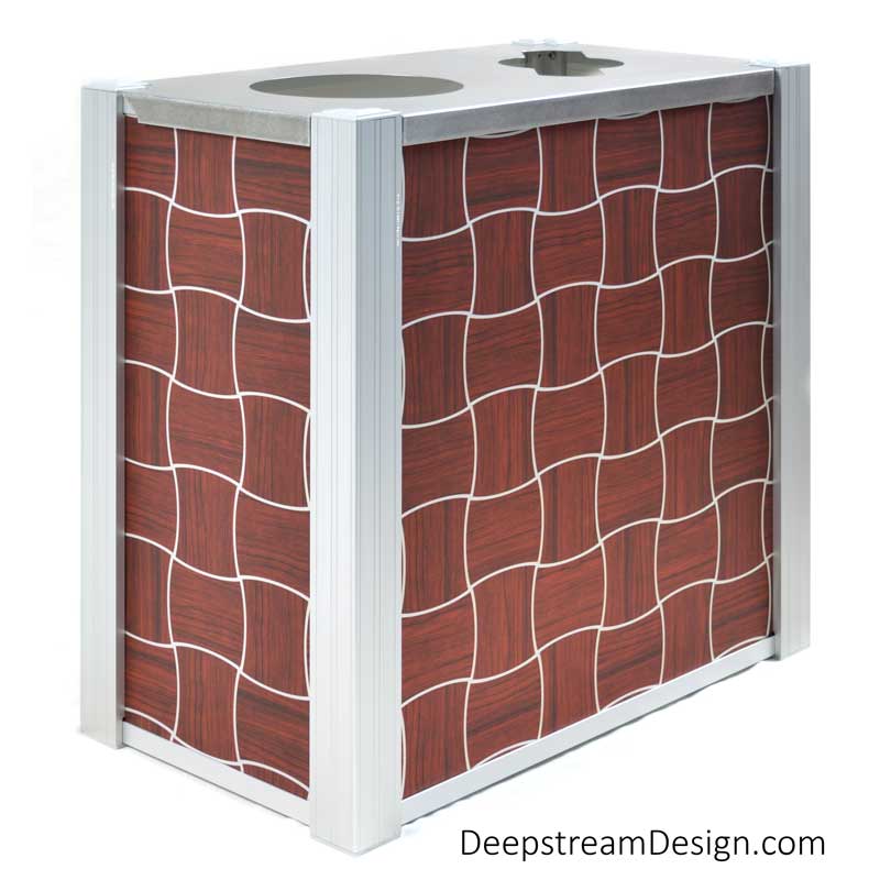A studio photo of an Audubon dual-stream Modern Commercial Combined Recycling and Trash Receptacle with side panels using ATI Laminates Fusion Aluminum Panel with the Puzzle pattern printed in silver on dark cherry wood background as a panel option.