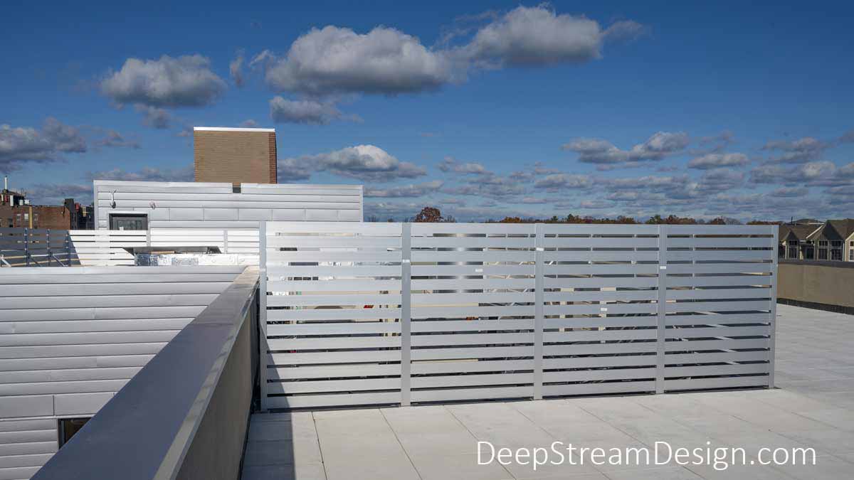 Anodized Aluminum Screen Wall photographed on a modern apartment building roof deck hides mechanical systems like HVAC equipment.