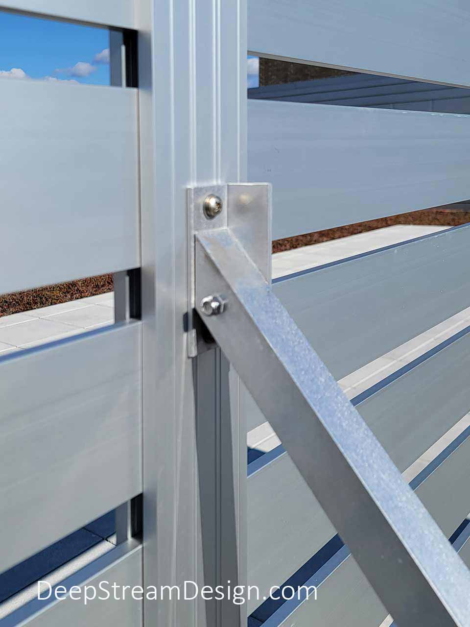 Roof Deck photo showing the detail of an aluminum strut attachment supporting DeepStream's anodized aluminum extrusion which joins two panels that make up a section of Modern Architectural Commercial Screen Wall enclosing Rooftop Mechanical Systems.